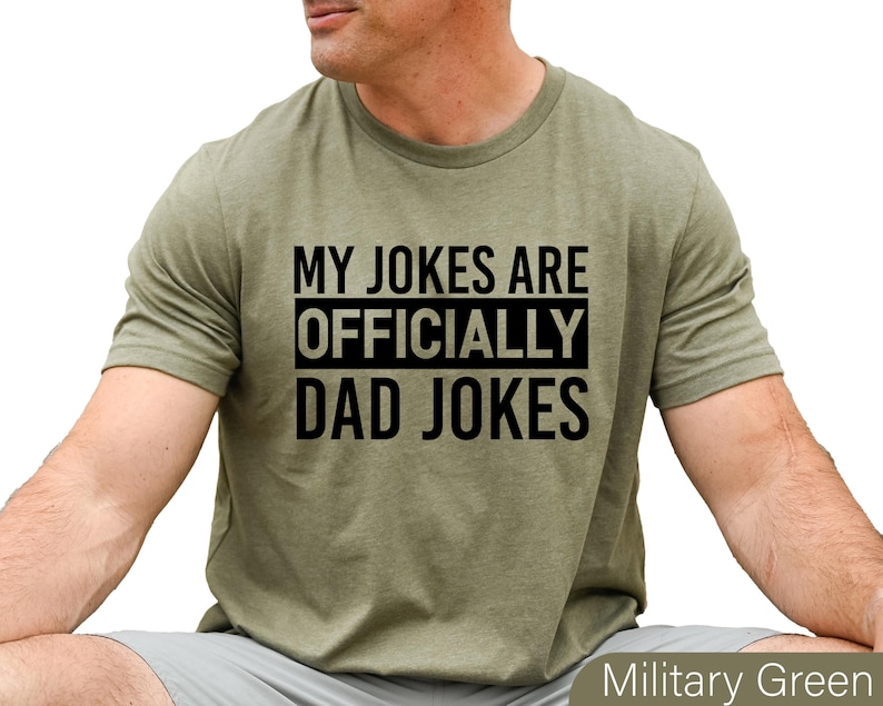 a man wearing a military green t - shirt that says, my jokes are officially