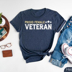 a t - shirt that says proud female veteran next to a pair of jeans and