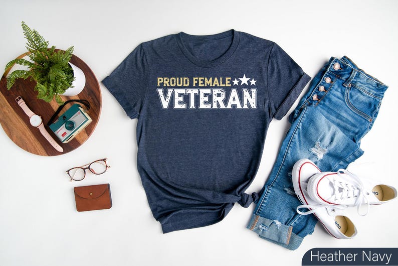 a t - shirt that says proud female veteran next to a pair of jeans and