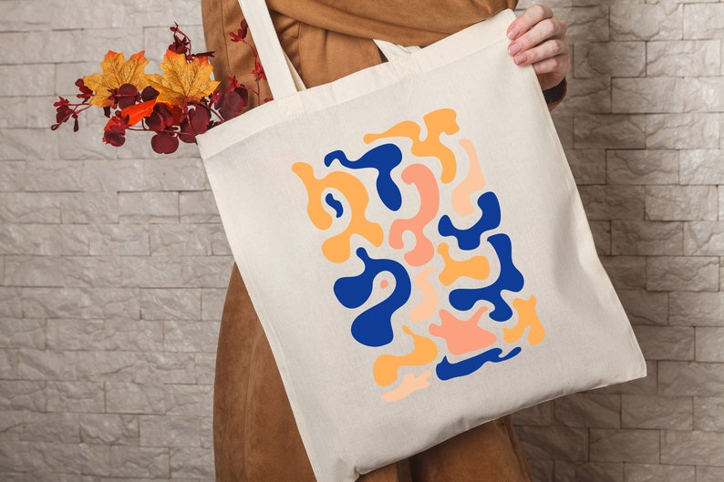 a person holding a tote bag with a design on it