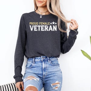 a woman wearing a black sweatshirt and ripped jeans