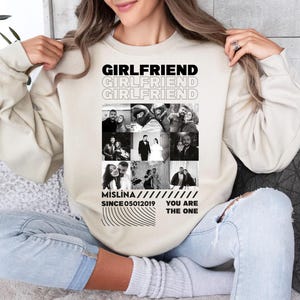 a woman sitting on a couch holding a shirt