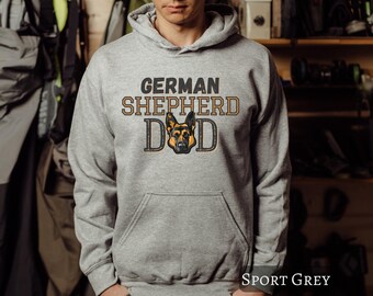 May include: A gray hooded sweatshirt with the text "GERMAN SHEPHERD DAD" and a German Shepherd dog head graphic. The sweatshirt is available in the color "SPORT GREY".