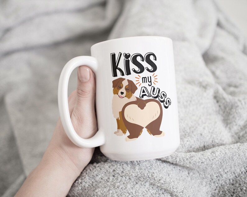 May include: White ceramic mug with a brown and white Australian Shepherd dog illustration. The text "Kiss my Aus" is printed on the mug.