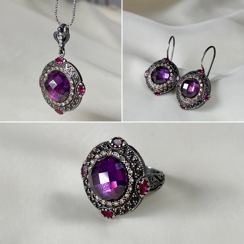 Puede incluir: Un conjunto de joyas de plata con piedras preciosas moradas y rosas. El conjunto incluye un collar, pendientes y un anillo.