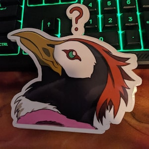 May include: A sticker of a cartoon bird with a question mark above its head. The bird has a pink, white, and black body with red feathers on its head. The bird is looking up.