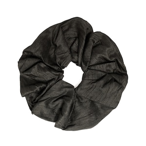May include: A black scrunchie made of fabric with a gathered, ruffled texture.