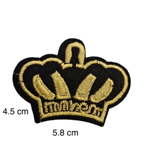 May include: A gold embroidered crown patch on a black felt background. The crown is 5.8 cm wide and 4.5 cm tall.