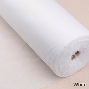 Pode incluir: Um rolo branco de tecido não tecido. O tecido é liso e tem um brilho ligeiro. O rolo tem um diâmetro de aproximadamente 30 cm e um comprimento de 90 cm.