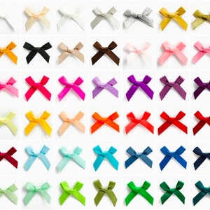 Puede incluir: Una colección de 36 lazos de cinta de satén de colores, cada uno atado en forma de lazo clásico. Los lazos están dispuestos en una cuadrícula, con cada lazo de un color diferente. Los colores incluyen rojo, naranja, amarillo, verde, azul, morado, rosa, blanco, negro y marrón.