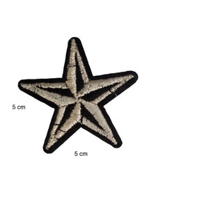 May include: Embroidered star patch with a black border and a beige center. The patch measures 5 cm by 5 cm. This decorative patch can be ironed on or sewn onto clothing, bags, or other fabric items.