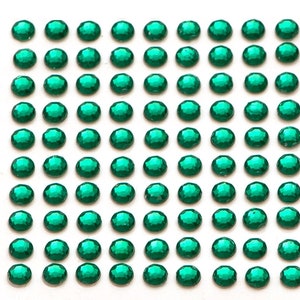 May include: A sheet of 100 self-adhesive green rhinestones. The rhinestones are round and have a faceted design.