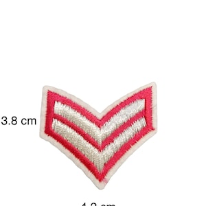 May include: A pink chevron patch with two white stripes. The patch is 3.8 cm wide and 4.2 cm long.