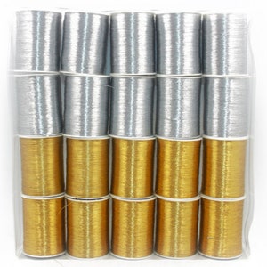 May include: A package of metallic thread spools in silver and gold. The spools are stacked in rows, with silver spools on top and gold spools below. The thread appears to be tightly wound on the spools.