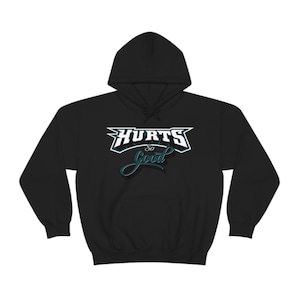 Op de afbeelding: Zwarte hoodie met de tekst "HURTS So Good" in witte en teal letters. De hoodie heeft een capuchon met trekkoord en een kangoeroezak. Een casual, comfortabel kledingstuk.