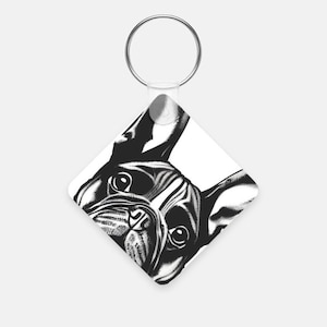 May include: Black and white illustration of a French bulldog's face on a white square keychain.