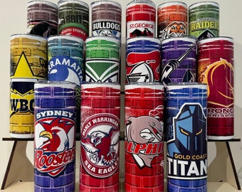 Op de afbeelding: Een verzameling van 16 roestvrijstalen bekers met verschillende teamlogo's en kleuren. De bekers hebben een bakstenen patroon achtergrond en teamnamen zoals "Sydney Roosters", "Manly Warringah Sea Eagles", "Gold Coast Titan" en "Brisbane Broncos".