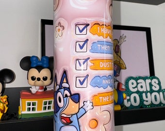 Op de afbeelding: Een roze en blauwe beker met een cartoonhond erop. De beker heeft een checklist met de tekst "Ik heb", "Dan", "Stof", "En kus", en "De sh".