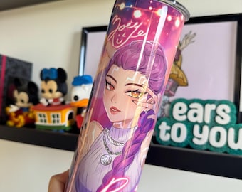 Op de afbeelding: Een roestvrijstalen beker met een anime-stijl illustratie van een vrouw met paars haar en een witte trui. De beker heeft de tekst "Joey Rumi" en een neonroze "Rumi" aan de zijkant. De achtergrond is een mix van roze, paars en blauw.
