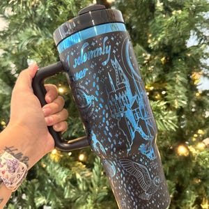 May include: A black travel mug with a blue and silver design featuring Hogwarts castle, a crescent moon, and the text "I solemnly swear that I am up to no good".