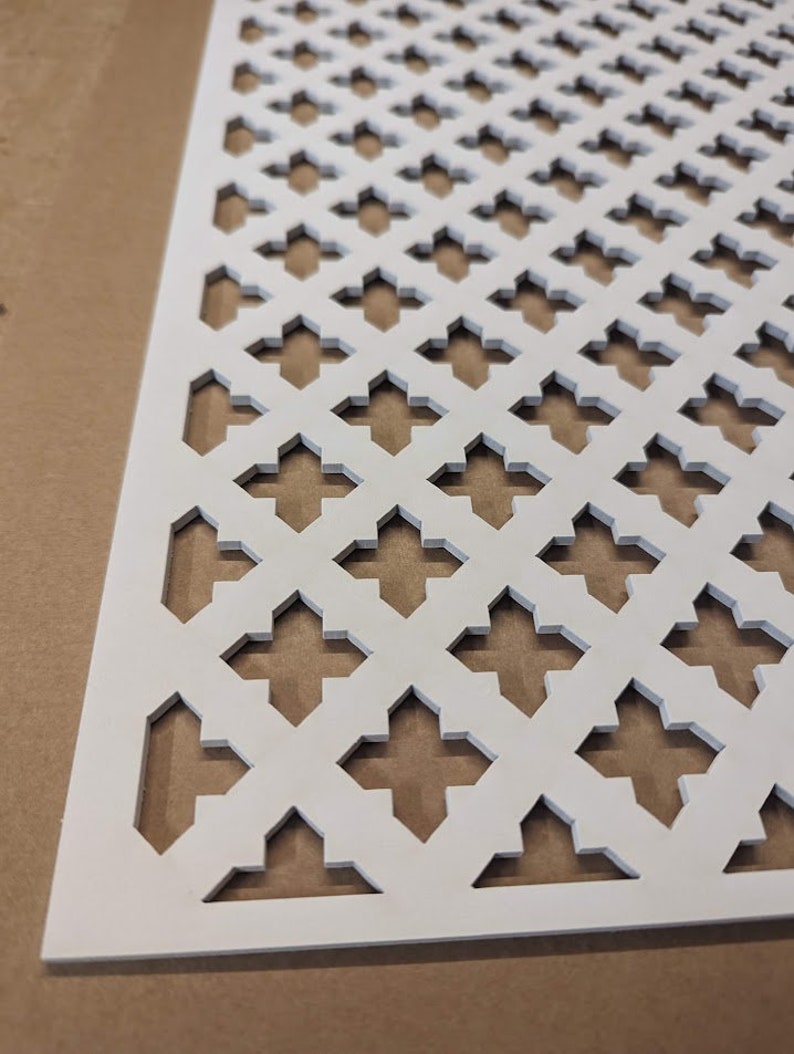 May include: White decorative metal sheet with a repeating geometric pattern of diamond shapes. The sheet has a grid-like design with cut-out shapes.