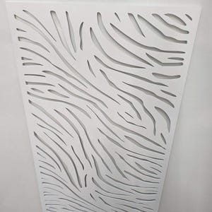 May include: White decorative wall panel featuring a cut-out design reminiscent of zebra stripes. The panel is crafted from a lightweight material and is suitable for indoor use.
