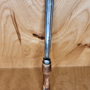 May include: A vintage wood handled metal carving tool with a long, thin blade.