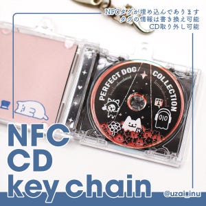 May include: A clear plastic CD case keychain featuring a removable circular disc with a black background, red floral accents, and white illustrations of a dog, a ghost, and the text PERFECT DOG COLLECTION. The case includes an embedded NFC tag.