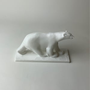 Può includere: Scultura in ceramica bianca di un orso polare che cammina su una base rettangolare.