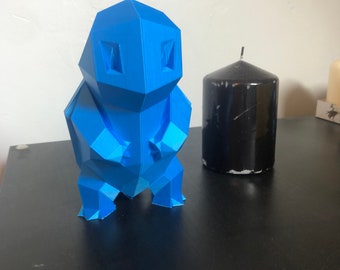 May include: A blue 3D printed geometric sculpture of a creature, standing on a black surface next to a black candle.
