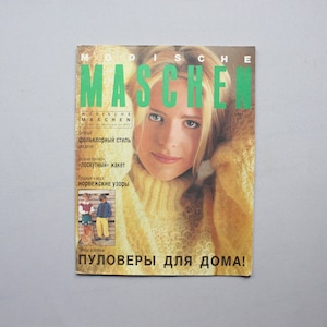 Peut inclure: Une couverture de magazine mettant en scène une femme portant un pull en laine jaune. Le magazine est intitulé "Modische Maschen" et porte la mention "Pulöver für doma!" en bas.