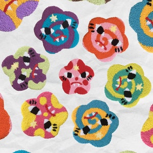 May include: A collection of 12 colourful, whimsical, embroidered flower-shaped patches with cartoon faces. Each patch features a different colour combination and design, including swirls, stars, and eyes.