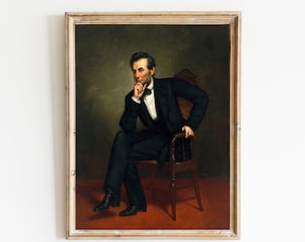 May include: A framed portrait of Abraham Lincoln in a black suit and bow tie, sitting in a wooden chair with his hand on his chin, against a dark green background.