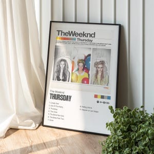May include: A framed poster of The Weeknd's "Thursday" album. The poster, in a black frame, displays the album title, tracklist, and images of women. The words "Wednesday" and "Friday" are also visible on the poster.