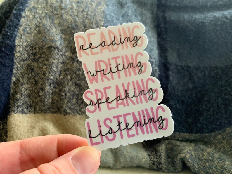 May include: A white sticker with the words "reading", "writing", "speaking", and "listening" in pink and black lettering.