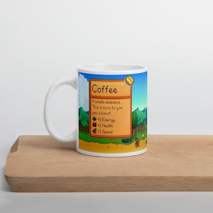 May include: White ceramic mug with a pixelated image of a coffee bean and text that reads "Coffee" and "It smells delicious. This is sure to give you a boost. +3 Energy +1 Health +1 Speed".