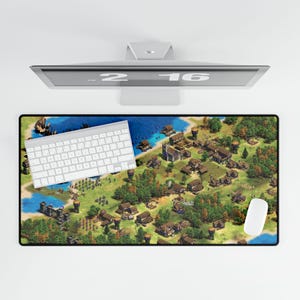 May include: A computer setup with a mouse mat featuring a detailed map design, a white keyboard, and a white mouse. The map shows a village scene with trees, buildings, and water. A computer monitor is above the mouse mat.