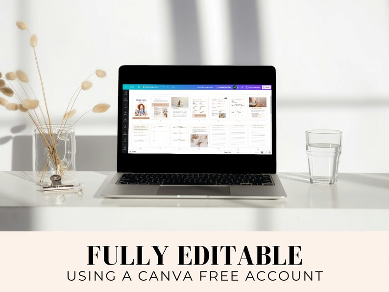 May include: A laptop computer displaying a Canva design template on the screen. The template is a planner with a light blue background and white text. The text on the screen says "Weekly Planner". The laptop is on a white desk with a glass of water and a vase of dried flowers.