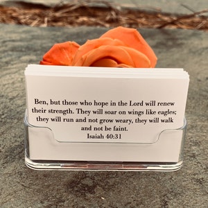 May include: A white card with a Bible verse from Isaiah 40:31. The verse reads, "Ben, but those who hope in the Lord will renew their strength. They will soar on wings like eagles; they will run and not grow weary, they will walk and not be faint. Isaiah 40:31."