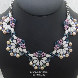 May include: A white, pink, and blue beaded necklace with a floral design. The necklace is made with small, faceted beads and pearls. The necklace is displayed on a black mannequin.