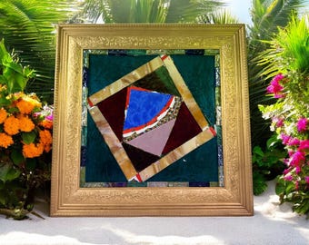 Könnte beinhalten: Ein gerahmtes abstraktes Kunstwerk mit einem goldfarbenen, verzierten Rahmen. Das Kunstwerk zeigt ein geometrisches Design mit einer Farbpalette aus Blau, Burgunderrot und Beige. Der Hintergrund ist dunkel türkis.