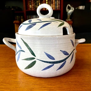 May include: White ceramic soup tureen with a lid and two handles. The tureen is decorated with a blue and green leafy design.