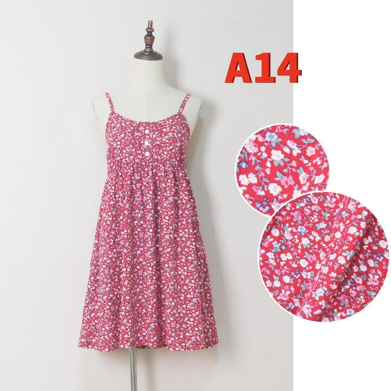 May include: A red floral print dress with spaghetti straps. The dress features a fitted bodice and a flared skirt. The fabric is covered in a pattern of small white, blue, and pink flowers. The text "A14" is in the upper right corner.