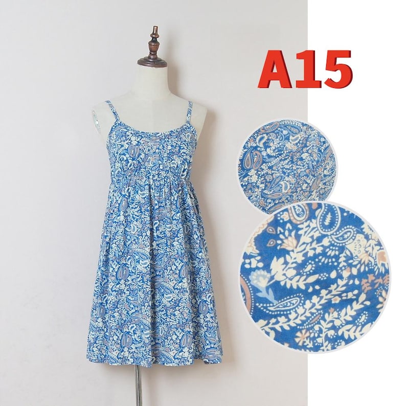 May include: A blue paisley print sundress with spaghetti straps, displayed on a mannequin. The dress features a gathered bodice and a flared skirt. The text "A15" is in the upper right corner. Two circular close-ups show the fabric pattern.
