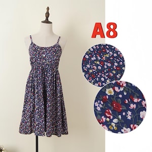 May include: A navy blue floral print dress with spaghetti straps and a button-down bodice. The dress is displayed on a mannequin. The text "A8" is in the upper right corner. Two close-up fabric samples are shown.