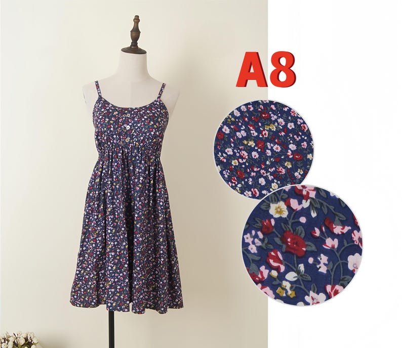 May include: A navy blue floral print dress with spaghetti straps and a button-down bodice. The dress is displayed on a mannequin. The text "A8" is in the upper right corner. Two close-up fabric samples are shown.