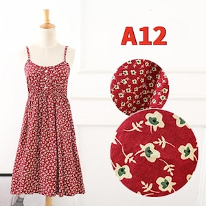 May include: A red floral print sundress with spaghetti straps and a button-down bodice. The dress is displayed on a mannequin. The text "A12" is in red. Two circular fabric swatches show the floral pattern.