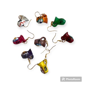 May include: A set of eight colorful ceramic pitcher earrings. Each earring features a different color and design, with intricate floral details. The earrings are made of clay and have a gold-colored hook.