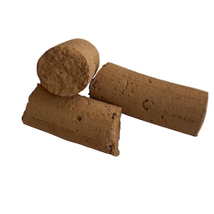 May include: Four brown corks of varying sizes are arranged against a white background. The corks have a cylindrical shape with a rough, textured surface. One cork is cut at an angle, revealing the interior.