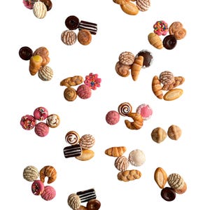 May include: A variety of colorful Mexican pastries, including conchas, pan dulce, and donuts, are scattered on a white background.